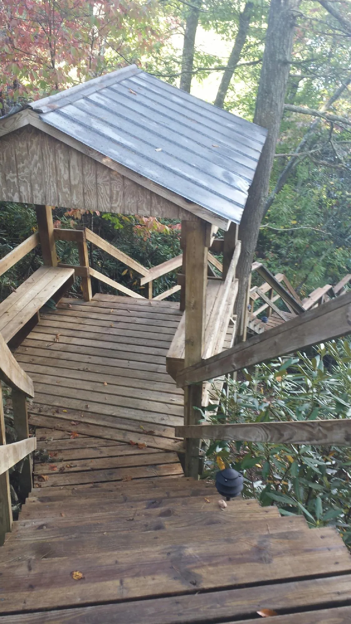 Metal roofed shelter over wooden steps on a wooded walkway — Skylight Repair & Installation work by our crew in Stormville