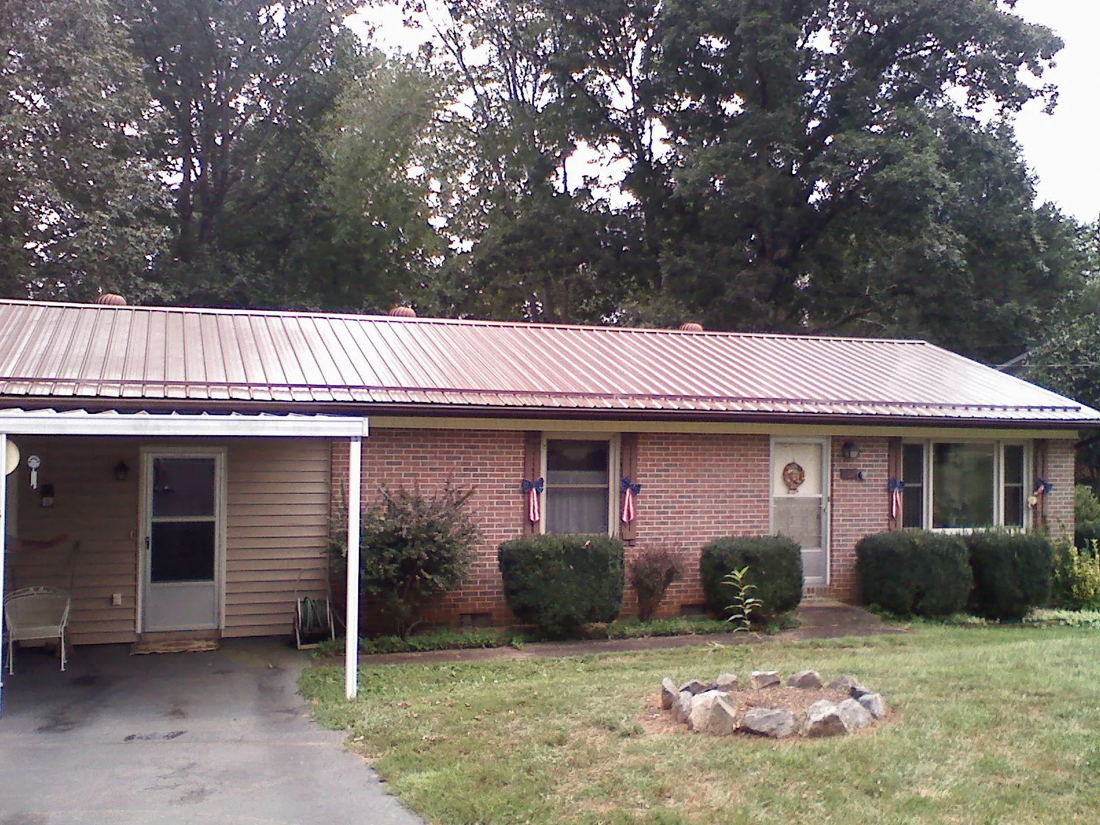 Bronze metal roof and carport on a brick ranch home — Roof Repair work by our crew in Stormville